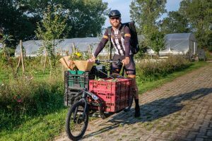 Peter Rugge van Go Fast bicycle deliveries bezorgt groente en bloemen van de moestuin van de Stadsakker met de cargobike.