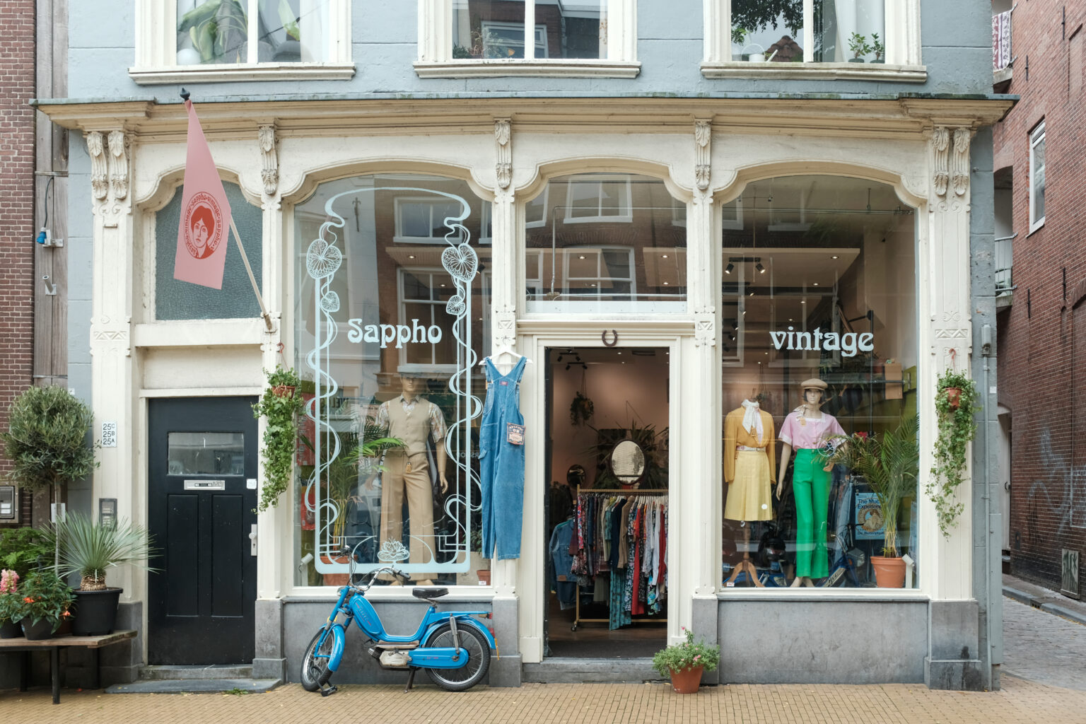 Voorgevel van vintage winkel Sappho aan de Steentilstraat met etalagepoppen, planten en blauwe scooter