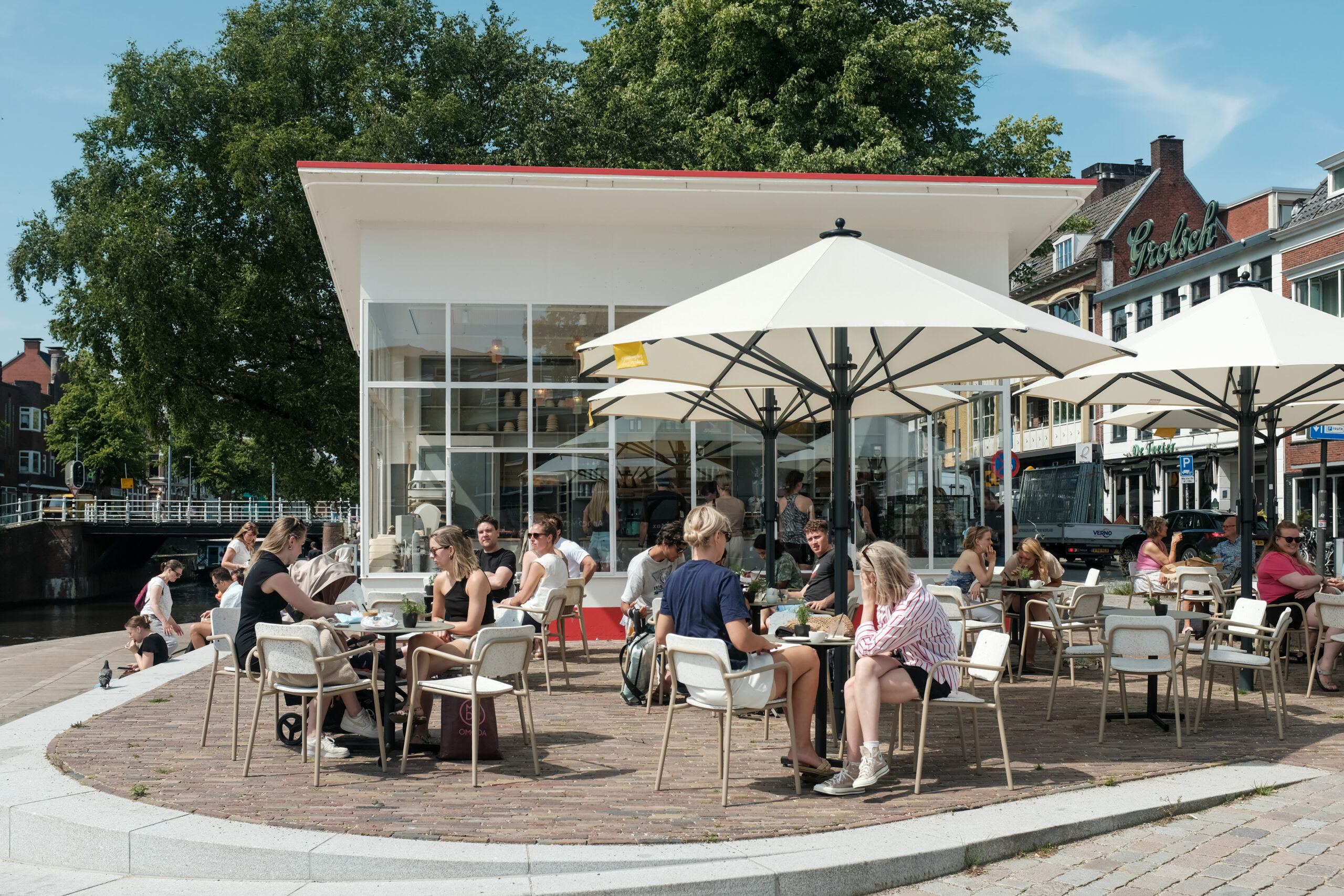 Gasten op het terras van Van Deeg Vandaag aan de Turfsingel in Groningen bij het voormalige benzinestation ontworpen door Diudok