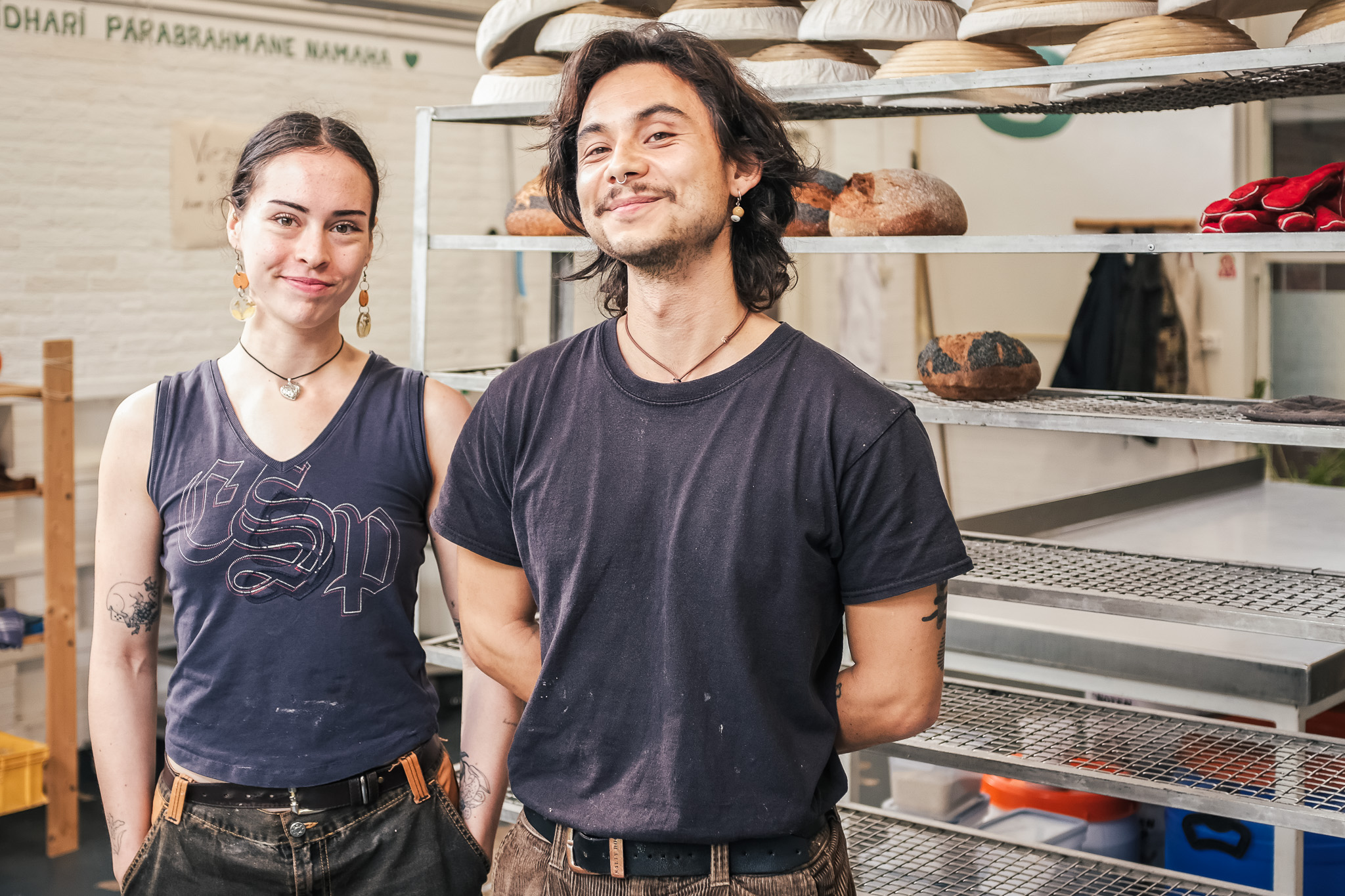 Robin en Mali, oprichters van Tochka Bakery in Groningen, in hun ambachtelijke bakkerij tussen rekken vol versgebakken zuurdesembrood.