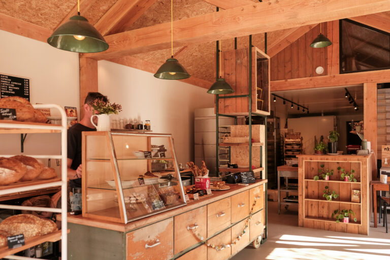 Interieur met veel hout van Bakkerij Stoet met toonbank, brood en buns. Deze bakker is gevestigd aan de Rijkstraatweg 32 in Glimmen