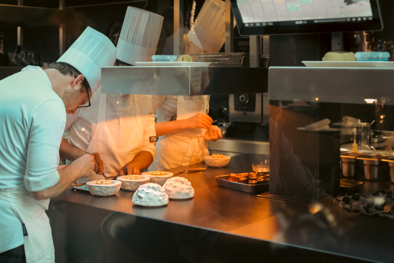 Chef-koks bereiden verfijnde gerechten in de open keuken van restaurant Noor in Hoogkerk, bekroond met een Michelinster.