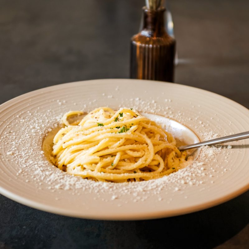 Een bord spaghetti aglio olio bij restaurant Amici aan de Astraat in Groningen, met knoflook, olijfolie en Parmezaanse kaas.